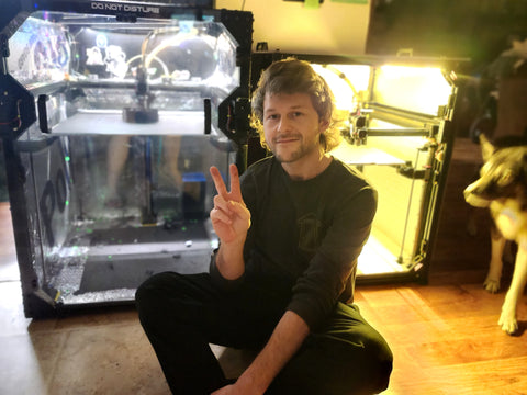 Austin Lee sitting in front of his 2 RatRigs, the V-Core 3 and the V-Core 4. There's also a blurry pic of his dog.